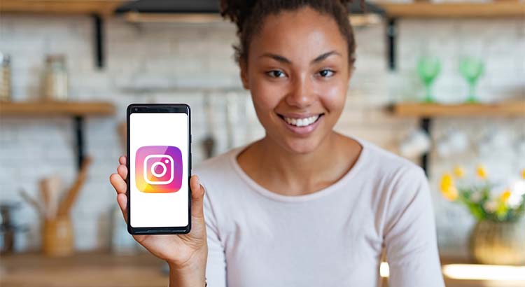 Mulher segurando celular com o logo do Instagram