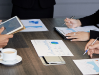 Pessoas com papeis e tablet na mesa